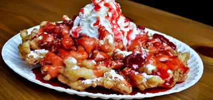 Image of Funnel Cake with strawberries and whipped cream on top.