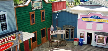 Image off the buildings in Dawson City. The buildings look like they are straight from a western film. The buildings are blue, green and pink.