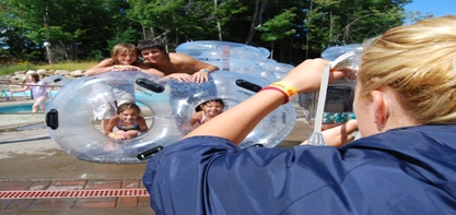 Image of three kids sticking their heads out of the holes in the three people tubes for the water rides.