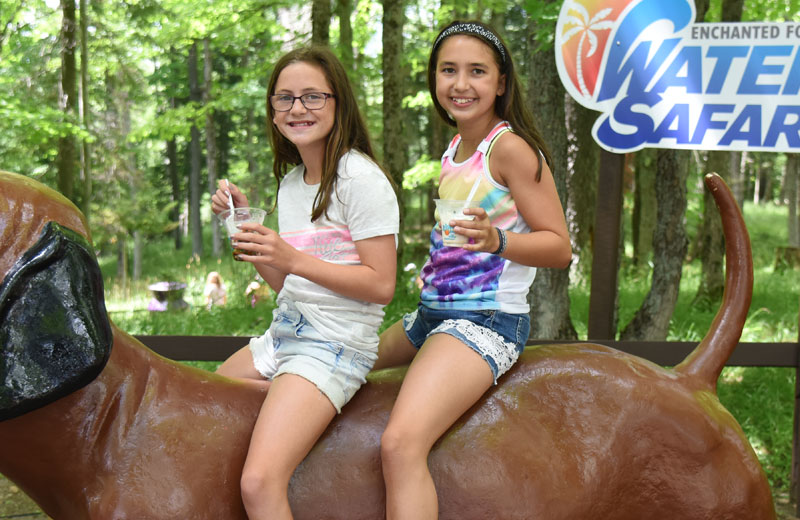 2 girls on statue of dog with ice cream