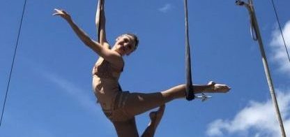 a circus performer doing a performance on ropes in the air